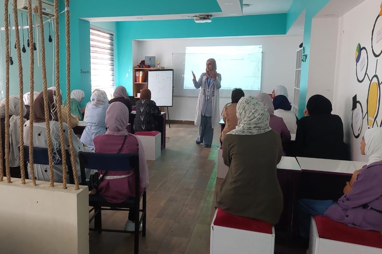 A woman is standing in front of a students class