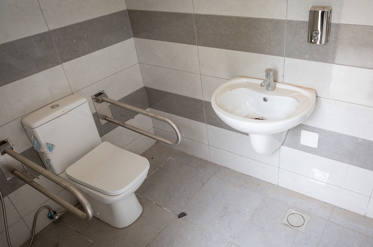 A white inclusive toilet and a white sink