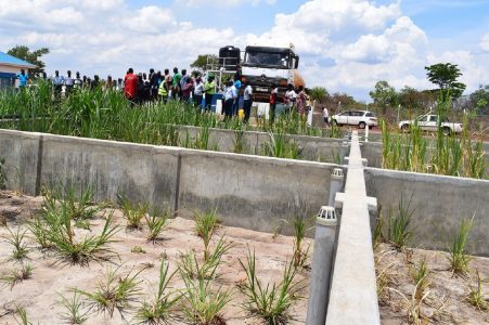 A waterwater treatment plant with people standing in the background.