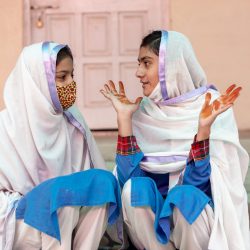 Two girls are sitting on a staircase and talking