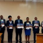 Foto de grupo de los participantes durante la presentación de los estudios de caso sobre infraestructuras de saneamiento. Las personas sostienen en sus manos los informes impresos.