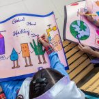 Two girls painting colourful picture on the occasion of World Handwashing Day